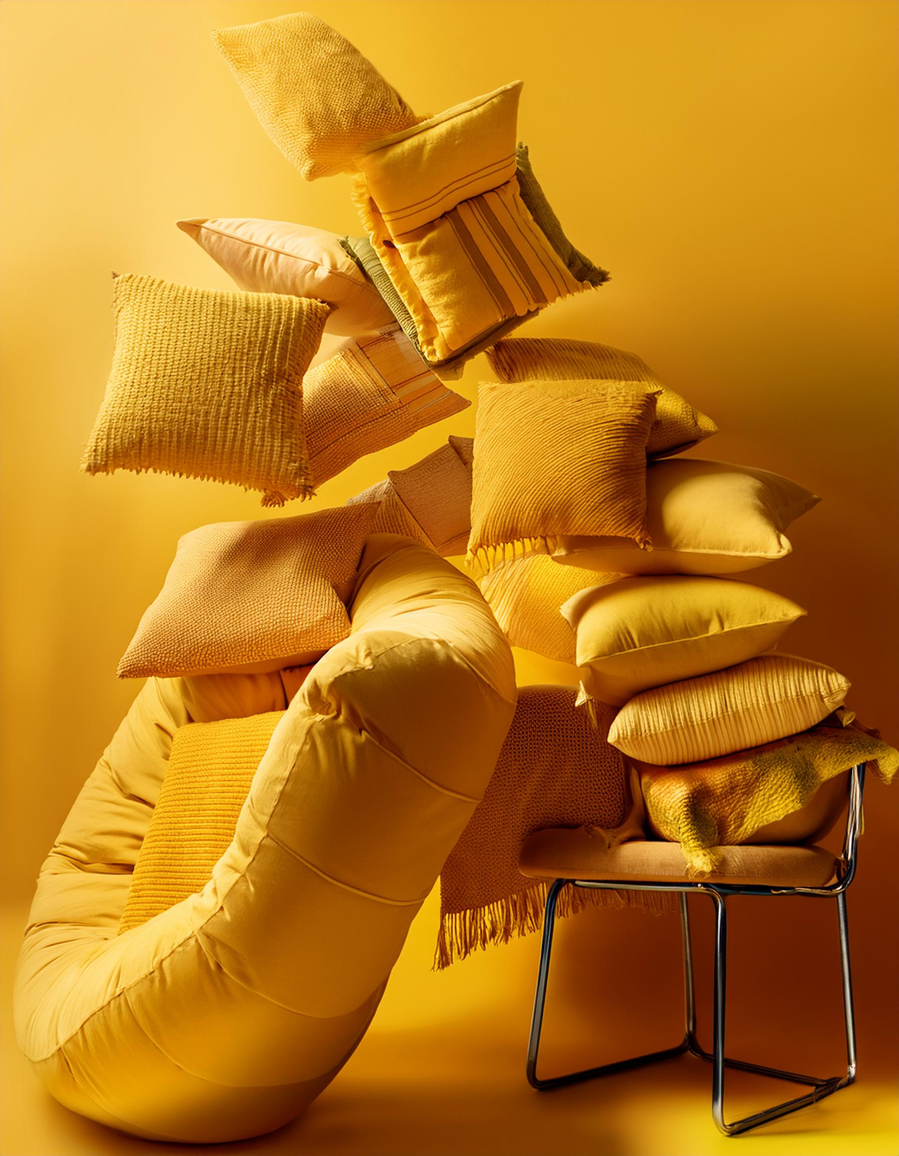 Home Textiles Sourcing Yellow pillows and cushions artistically arranged against a matching yellow background for a creative interior decor display